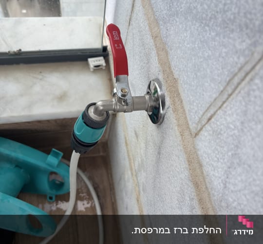 ברז מים עם צינור מחובר על קיר